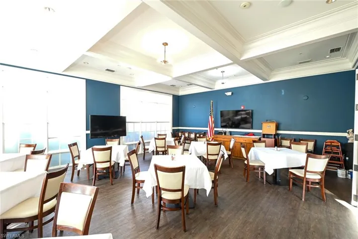 Dining room featuring crown molding, coffered ceiling, and dark hardwood / wood-style flooring