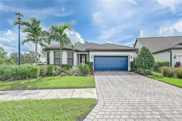 View of front of house featuring a garage and a front lawn