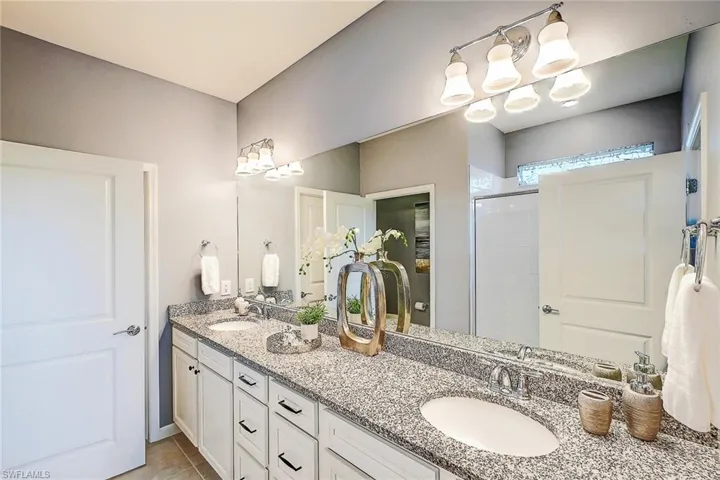 Bathroom with vanity, an enclosed shower, and tile patterned floors