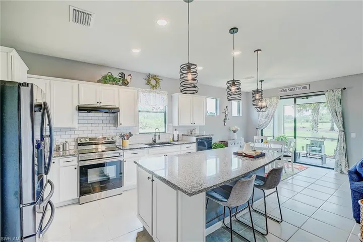 Kitchen with stainless steel appliances, sink, a center island, and a healthy amount of sunlight
