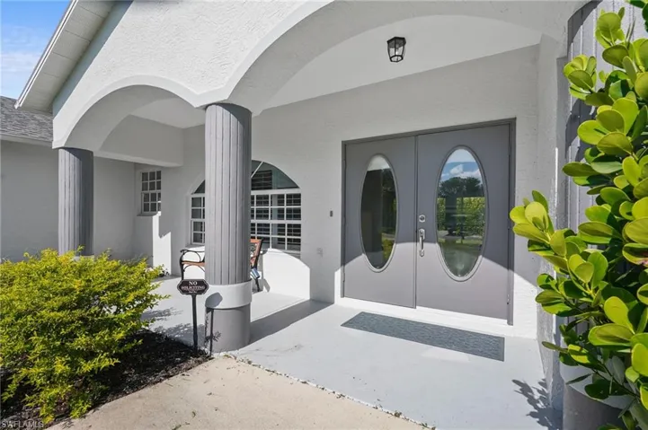 Doorway to property featuring french doors and stucco siding