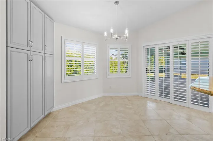 Unfurnished dining area featuring a chandelier and light tile patterned floors