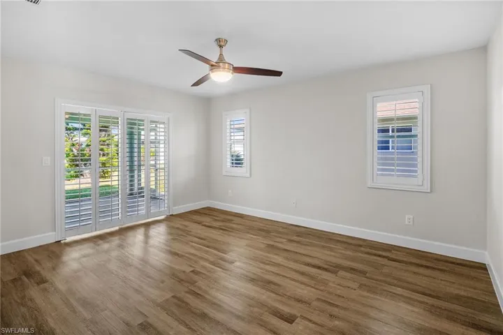 Unfurnished room with wood finished floors and a ceiling fan