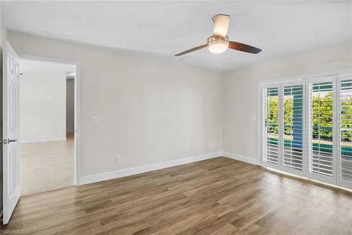 Empty room with wood finished floors and ceiling fan