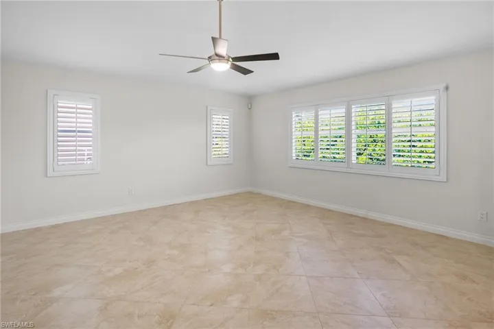 Unfurnished room featuring healthy amount of natural light and a ceiling fan