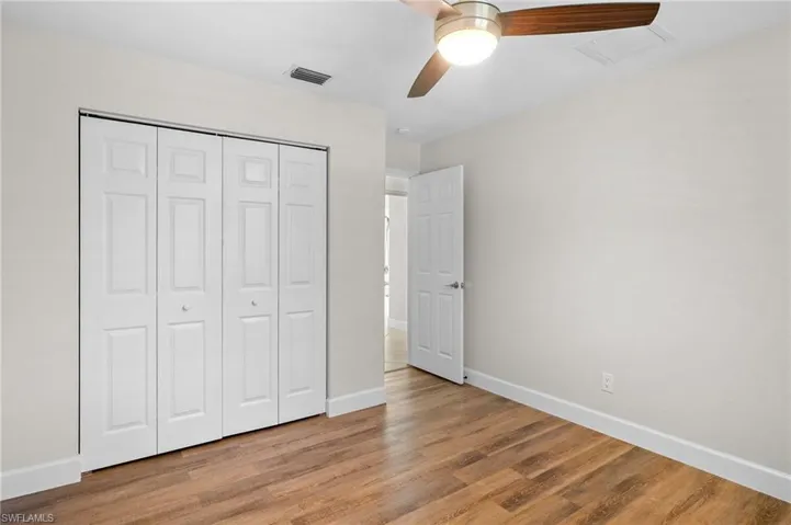 Unfurnished bedroom featuring light wood finished floors, a closet, and a ceiling fan