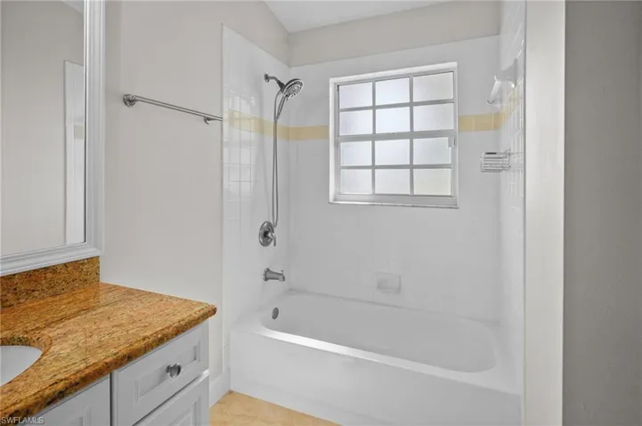 Bathroom with vanity, bathtub / shower combination, and tile patterned floors