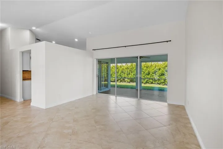 Empty room with recessed lighting, tile patterned floors, and high vaulted ceiling