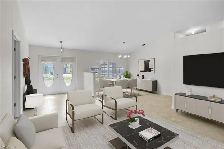 Living area with a chandelier, french doors, vaulted ceiling, and light tile patterned flooring