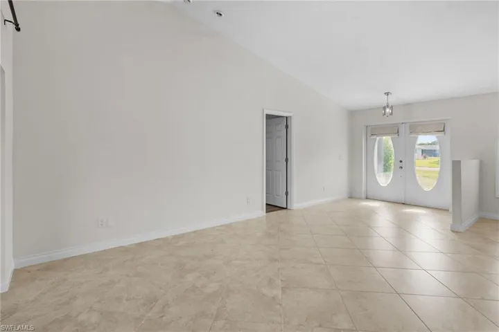 Spare room with french doors, high vaulted ceiling, and light tile patterned floors
