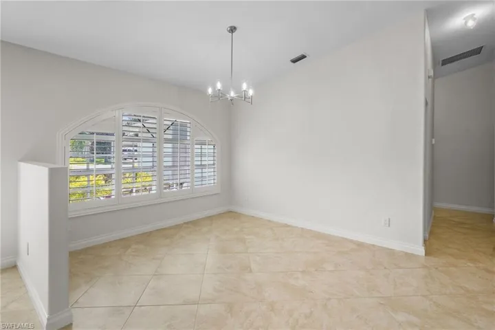 Unfurnished dining area featuring a chandelier and tile patterned flooring