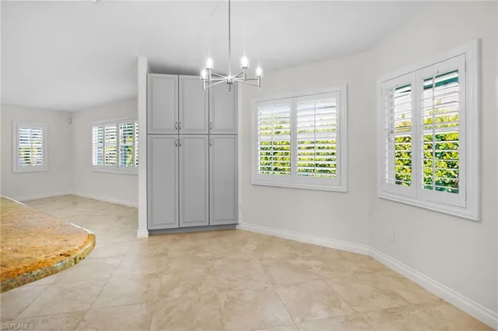Unfurnished dining area with a chandelier and light tile patterned floors