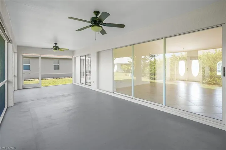 Unfurnished sunroom featuring a ceiling fan