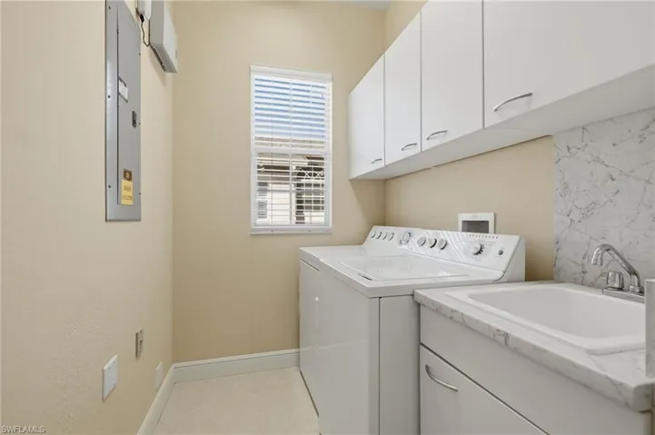 Updated Laundry Room with Custom CabinetryFeaturing new cabinetry, quartz countertops, a utility sink, abundant storage, and natural light, this spacious laundry room blends style with everyday functionality.