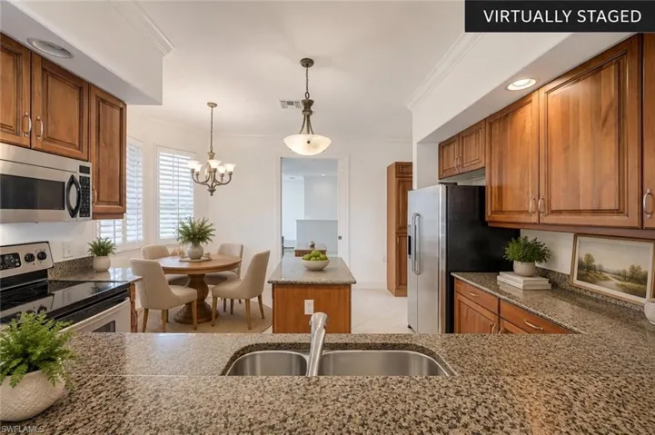 Enjoy a spacious kitchen featuring granite countertops, abundant wood cabinetry, a center island, breakfast bar, and a bright breakfast nook. The open design offers excellent flow to the dining and living areas, making this space ideal for entertaining and everyday living in The Vineyards. (Virtually staged.)