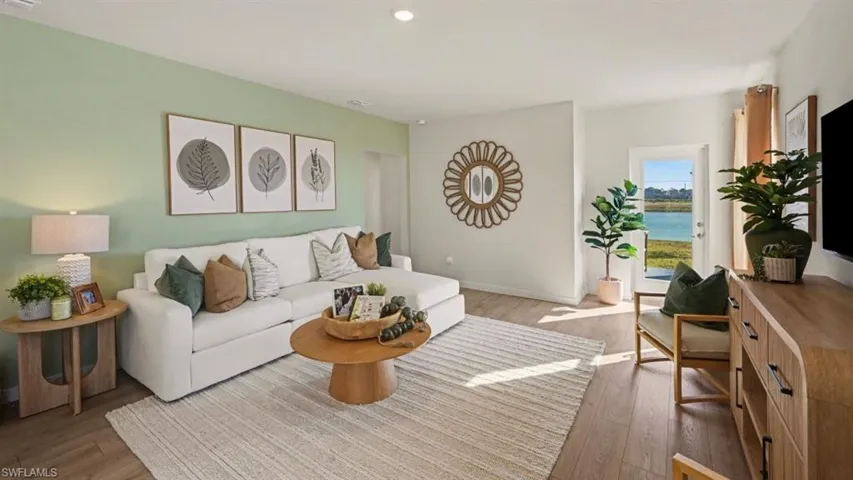 Spacious living area featuring light wood-finish flooring, recessed lighting, and direct outdoor access
