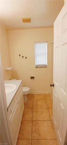 Bathroom featuring vanity, light tile patterned floors, and a shower