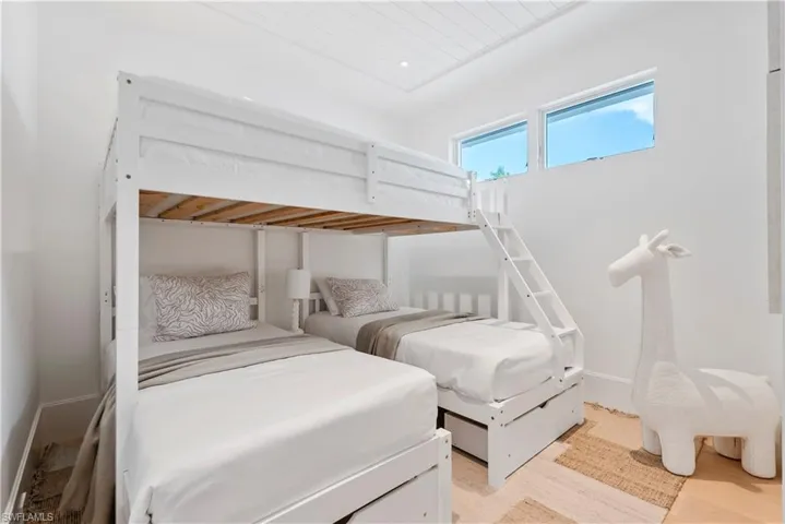Bunk room with light wood-type flooring and wood ceiling