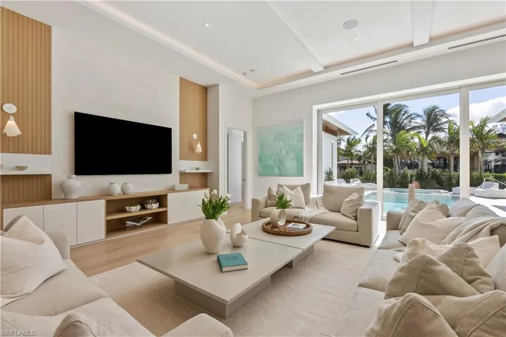 Living room with beamed ceiling and light hardwood / wood-style flooring