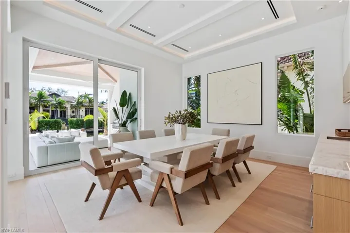 Dining room with a wealth of natural light, light hardwood / wood-style flooring, and beamed ceiling