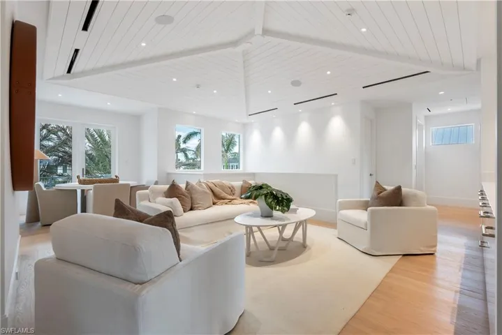 Living room featuring beamed ceiling, high vaulted ceiling, wooden ceiling, and light wood-type flooring