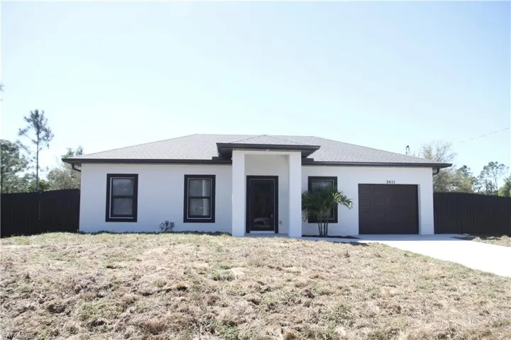 View of front facade with an attached garage, a shingled roof, fence, concrete driveway, and stucco siding