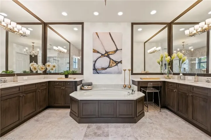 4056 Nova Ln. Naples FL 34119 - Owner's bath with separate vanities and mirrors to the ceiling
