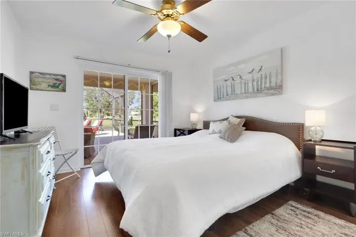 Bedroom featuring dark wood finished floors, access to outside, and ceiling fan
