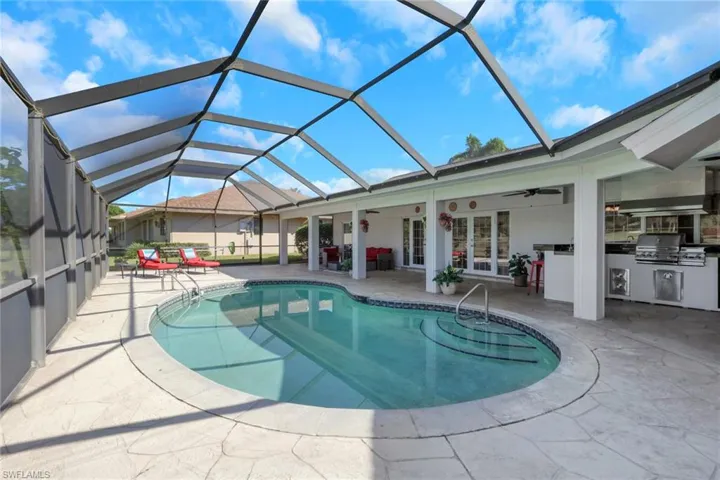 Swimming pool with a ceiling fan, a sunroom, a patio, and glass enclosure