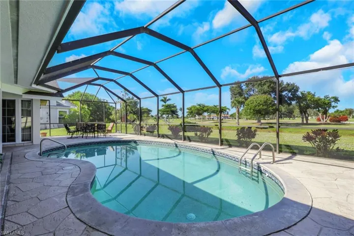 Swimming pool featuring a patio, a sunroom, a lanai, and a lawn