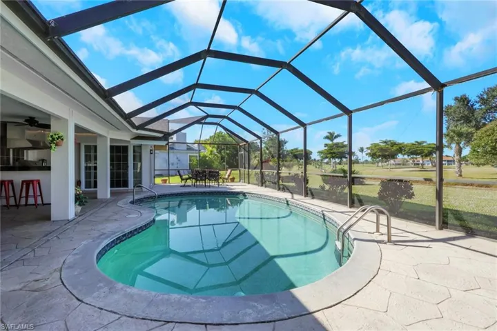 Swimming pool featuring a sunroom, a patio, a lanai, ceiling fan, and a yard
