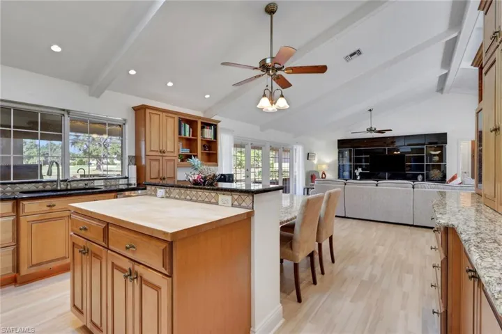 Kitchen with wood counters, light wood finished floors, a breakfast bar, a ceiling fan, and brown cabinetry