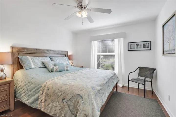 Bedroom with dark wood-style flooring and a ceiling fan