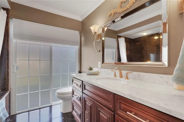 Bathroom with vanity, a shower with curtain, and ornamental molding