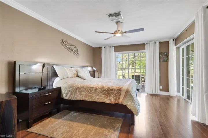 Bedroom featuring wood finished floors, crown molding, access to exterior, and ceiling fan