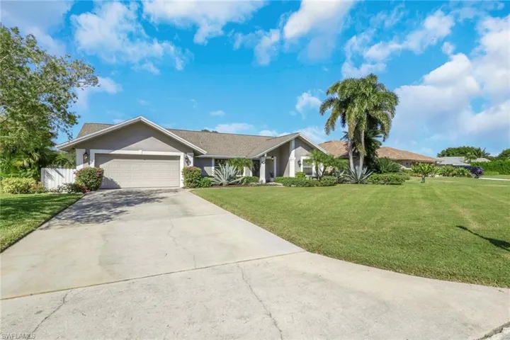 Single story home featuring stucco siding, a front yard, and driveway