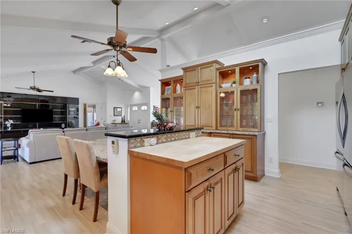 Kitchen featuring a breakfast bar area, light wood-style flooring, beamed ceiling, butcher block counters, and a kitchen island