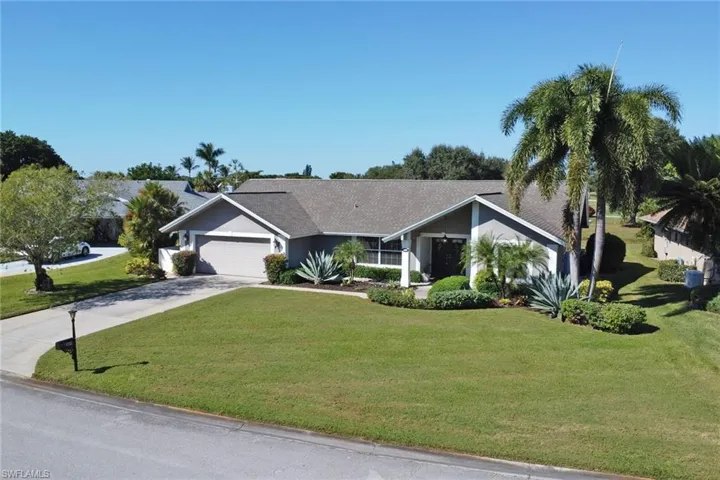 View of front facade with concrete driveway, a front lawn, a garage, and stucco siding