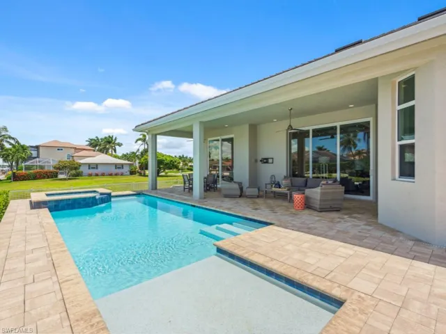 View of pool with an in ground hot tub, a patio, and an outdoor living space