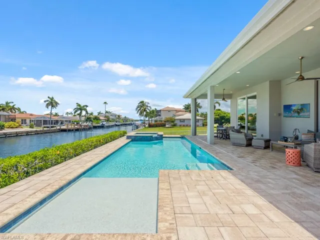 View of swimming pool with a water view, ceiling fan, a patio area, and an outdoor hangout area