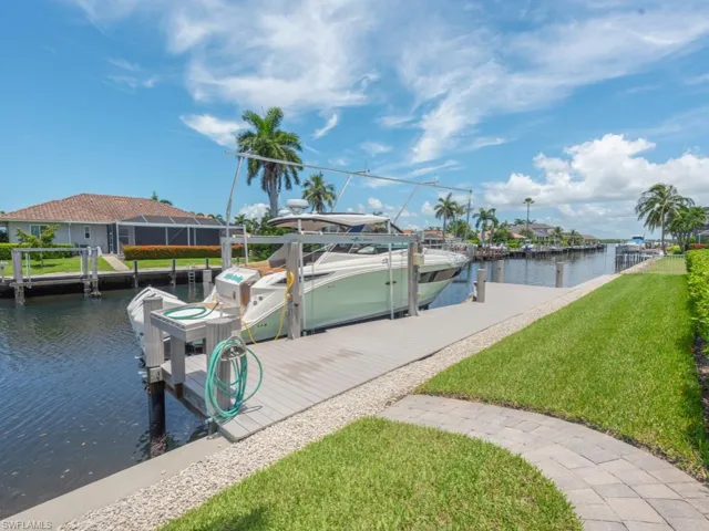 Dock area with a water view and a yard