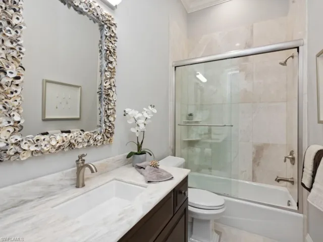 Full bathroom with crown molding, toilet, shower / bath combination with glass door, and vanity