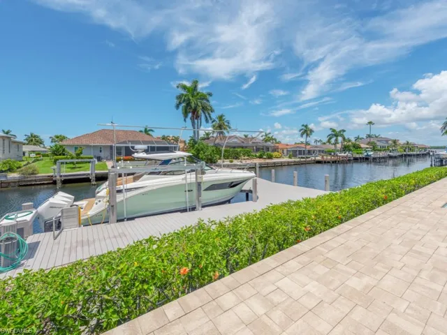View of home's community with a water view and a boat dock