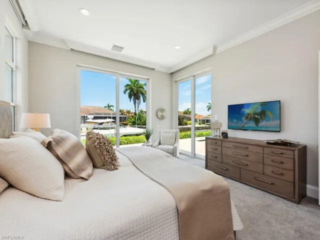 Bedroom featuring access to exterior, crown molding, and light carpet