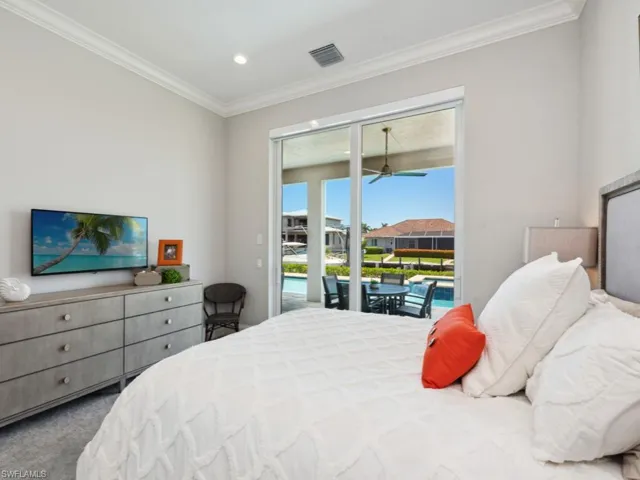 Carpeted bedroom with access to exterior and ornamental molding