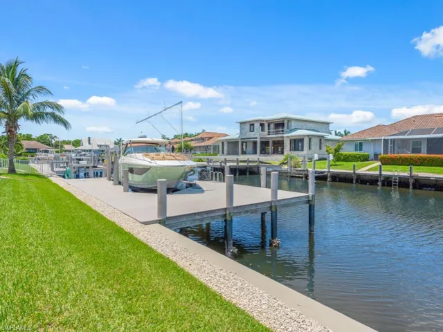 View of dock with a water view and a yard