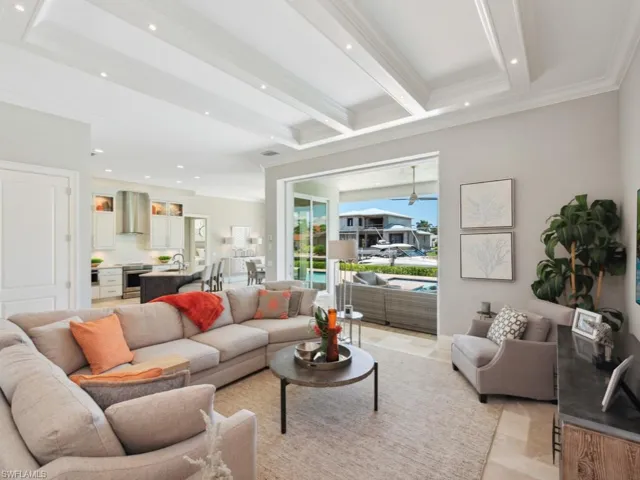 Living room featuring crown molding, light tile patterned floors, ceiling fan, beamed ceiling, and sink