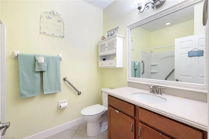 Bathroom with light tile patterned floors, vanity, and a shower