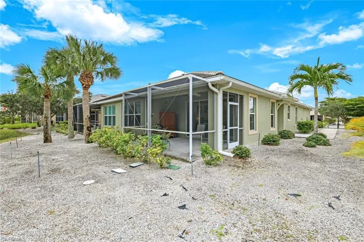 View of side of home with glass enclosure, stucco siding, and a sunroom
