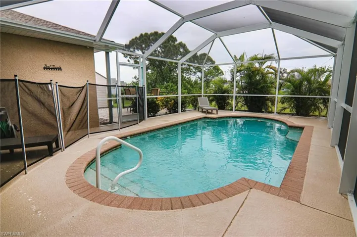 Swimming pool featuring a patio area and glass enclosure